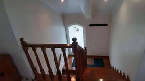 Eine Holztretreppe mit Handlauf, die zu einer Tür mit satiniertem Glas führt.