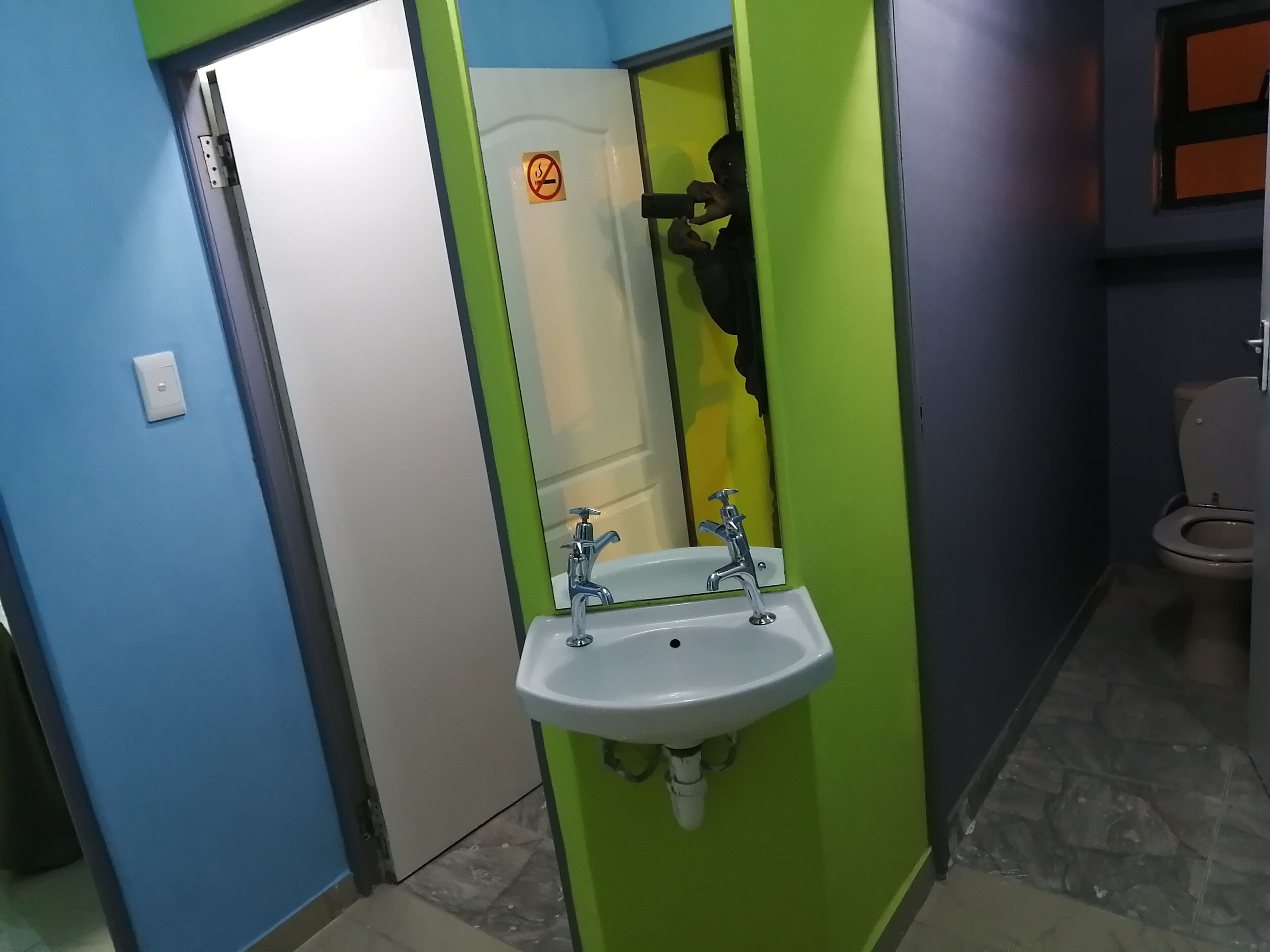 A bathroom with a white sink, a mirror, and a toilet.