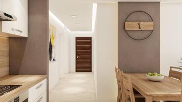 Una cocina moderna con armarios blancos, encimera de madera y horno empotrado.