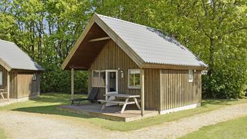 A wooden cabin with a covered porch and a picnic table.