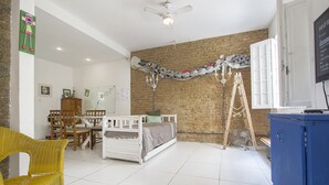 A room with a bed, a wooden chair, a table, and a fan. - LineRio Praia de Copacabana 372 (Rio de Janeiro)