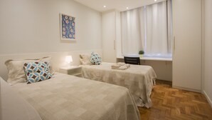 A hotel room with two beds, a nightstand, a window with curtains, and a small potted plant. - LineRio Praia de Copacabana 370.374 (Rio de Janeiro)