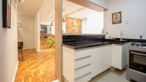 A modern kitchen with white cabinets, a black countertop, and a built-in oven. - LineRio Praia de Copacabana 370.374 (Rio de Janeiro)