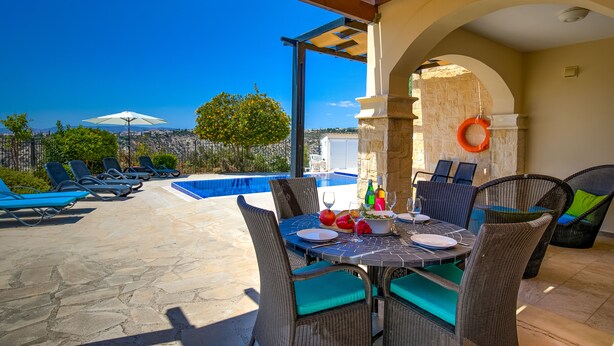 A rooftop terrace with a pool, outdoor seating, and a table set for dining. - Stunning 3 bedroom villa 'BZ01' with private pool, stunning views, communal pool and resort facilities, Zephyros Village on Aphrodite Hills Re (Kouklia)