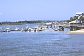 Overlooking a serene beach, this marina offers stunning views of a distant bridge.