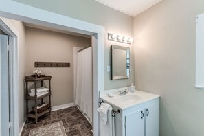 A bathroom with a white sink, mirror, and towel rack. - Charming House 1/2 Block from Bay (Fulton)