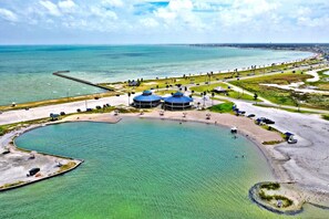 A coastal resort with a large swimming pool, beach, and a pier extending into the sea. - Charming House 1/2 Block from Bay (Fulton)
