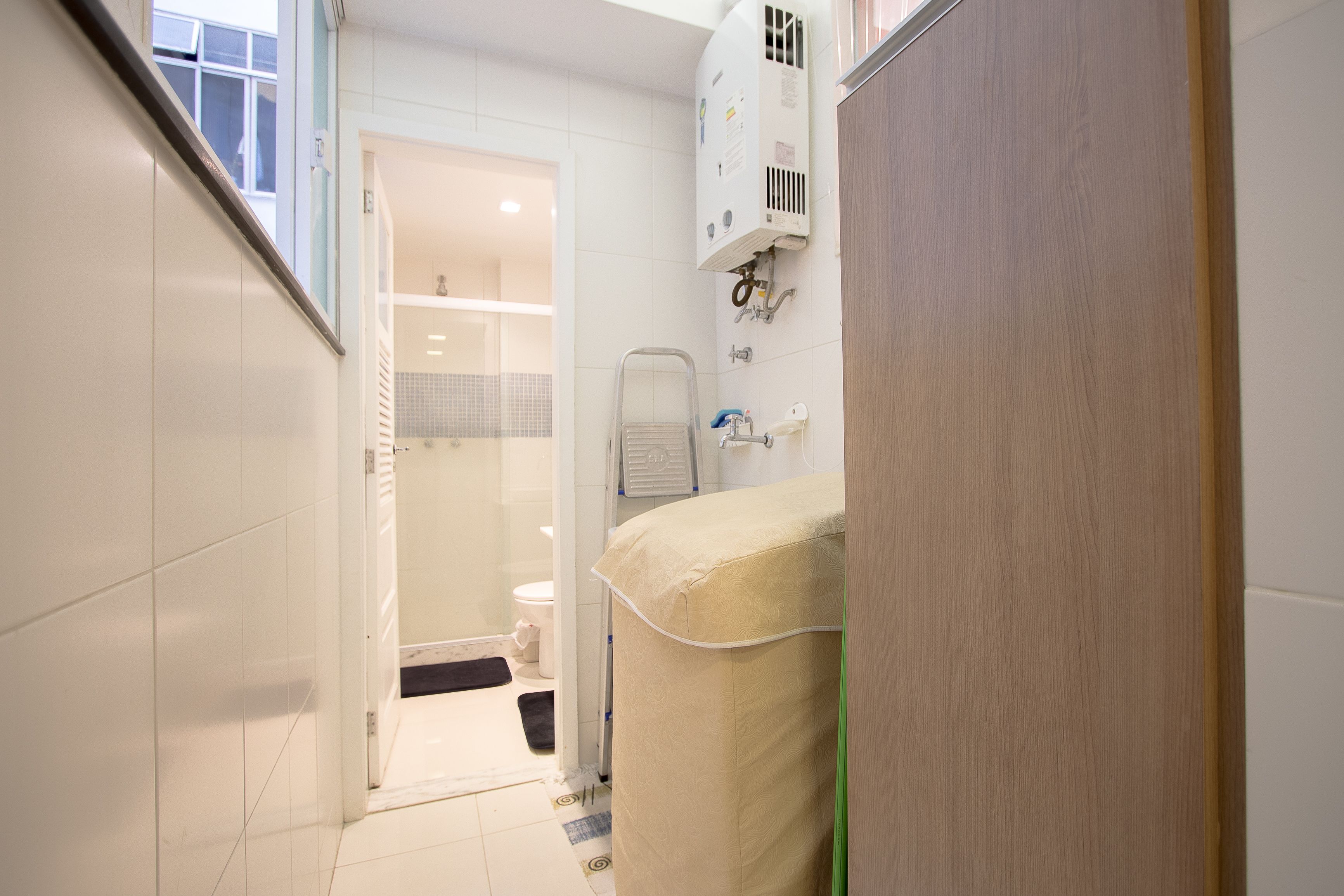 A narrow bathroom with a toilet, a shower, and a towel rack.
