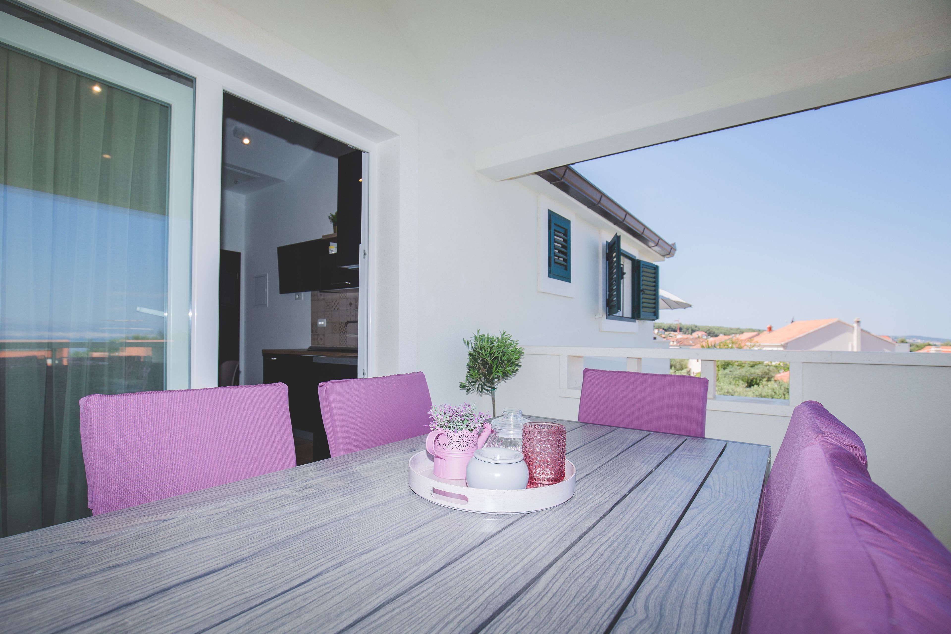 Un balcón con mesa, sillas y vistas al paisaje.