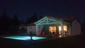 Una casa con piscina por la noche.