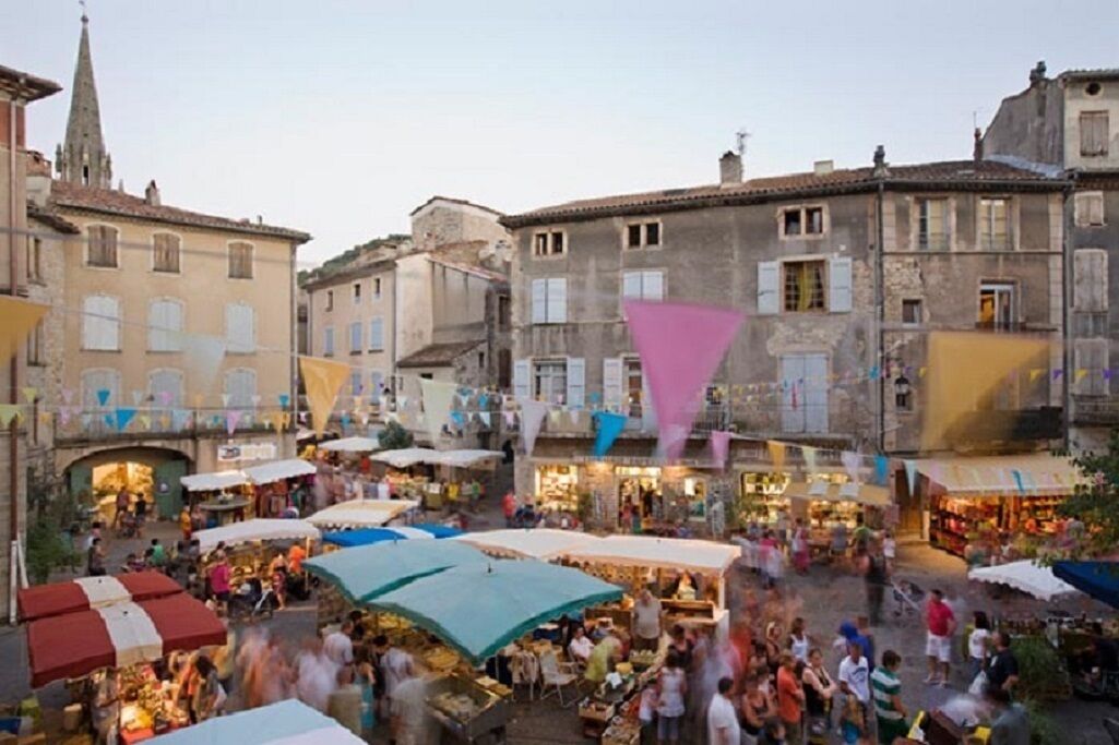 A bustling outdoor market with various stalls and people.