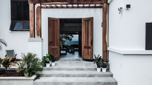 A staircase leading to a wooden door with a view of the sea. - Your Dream Costa Rica Villa - Ocean View Lap Pool - Private Chef-Secret Beach (Puerto Carrillo)