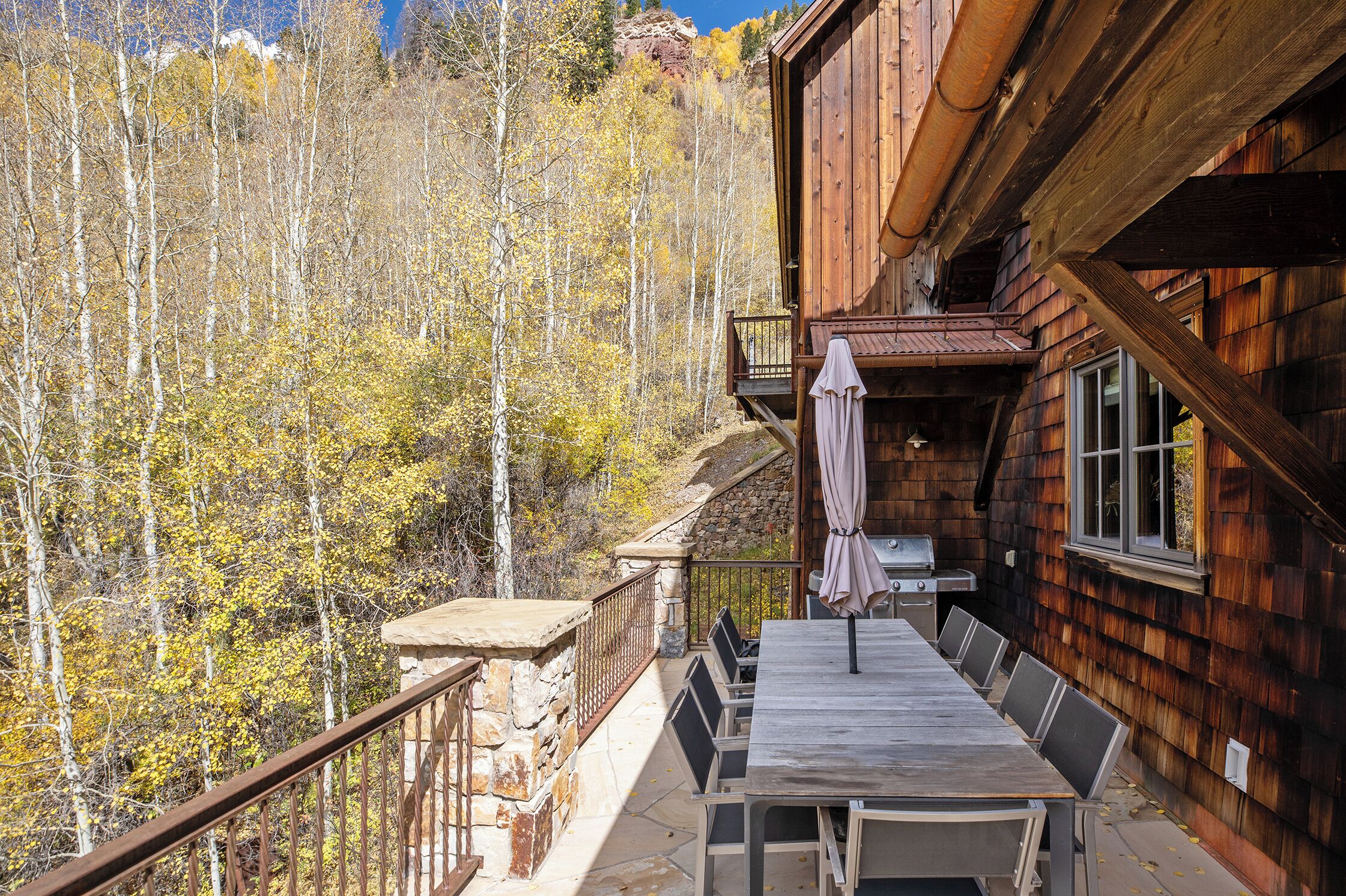 A wooden cabin with a balcony overlooking a forest.