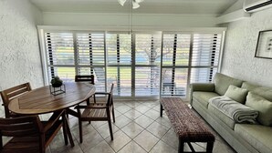 Une véranda comprenant une table à manger, des chaises, un banc, un canapé et un ventilateur de plafond.