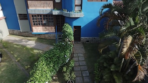 A blue building with a stone pathway leading to a door. - Ground floor chalet 230 meters from Enseada Beach and 3 minutes from the sand. (UBATUBA)