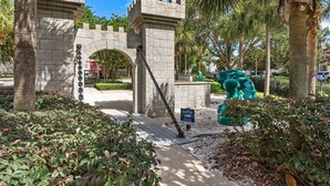 A stone archway with a selfie spot sign, surrounded by greenery and palm trees. - RATED#1 BEST HOME Near Disney! LUXURY 5BEDROOM 5Bath VILLA ,GATED RESORT ,POOL (Kissimmee)