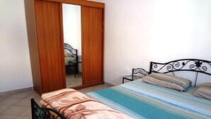 Ein Schlafzimmer mit Bett, Kleiderschrank und Spiegel.