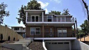 A modern two-story house with a flat roof, a balcony on the upper floor, and a garage. - Modern, new and close to lake (Lake Oswego)