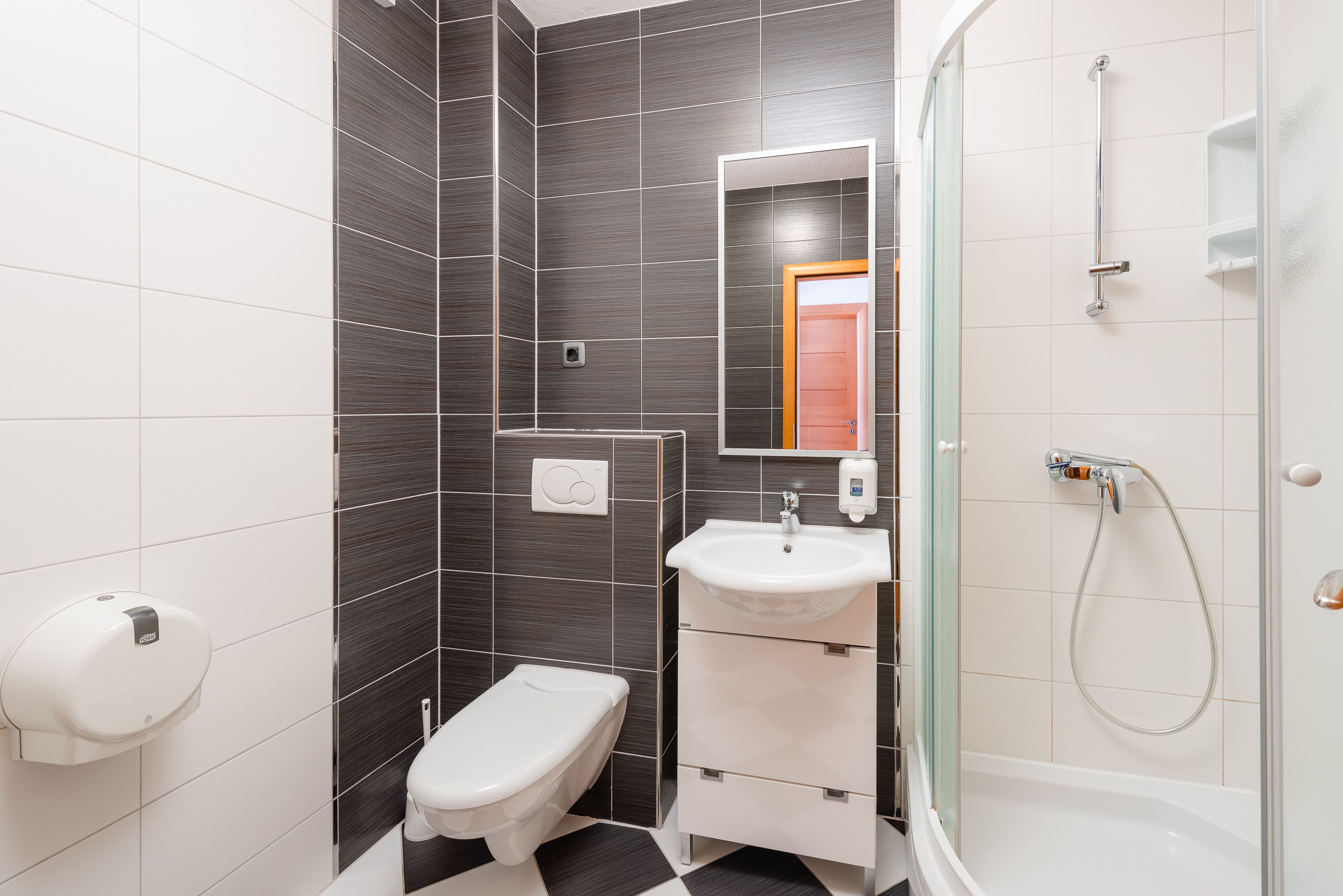 A modern bathroom with a toilet, sink, and shower.