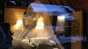 Une chambre avec un lit, un ventilateur de plafond et deux lampes fixées au mur.