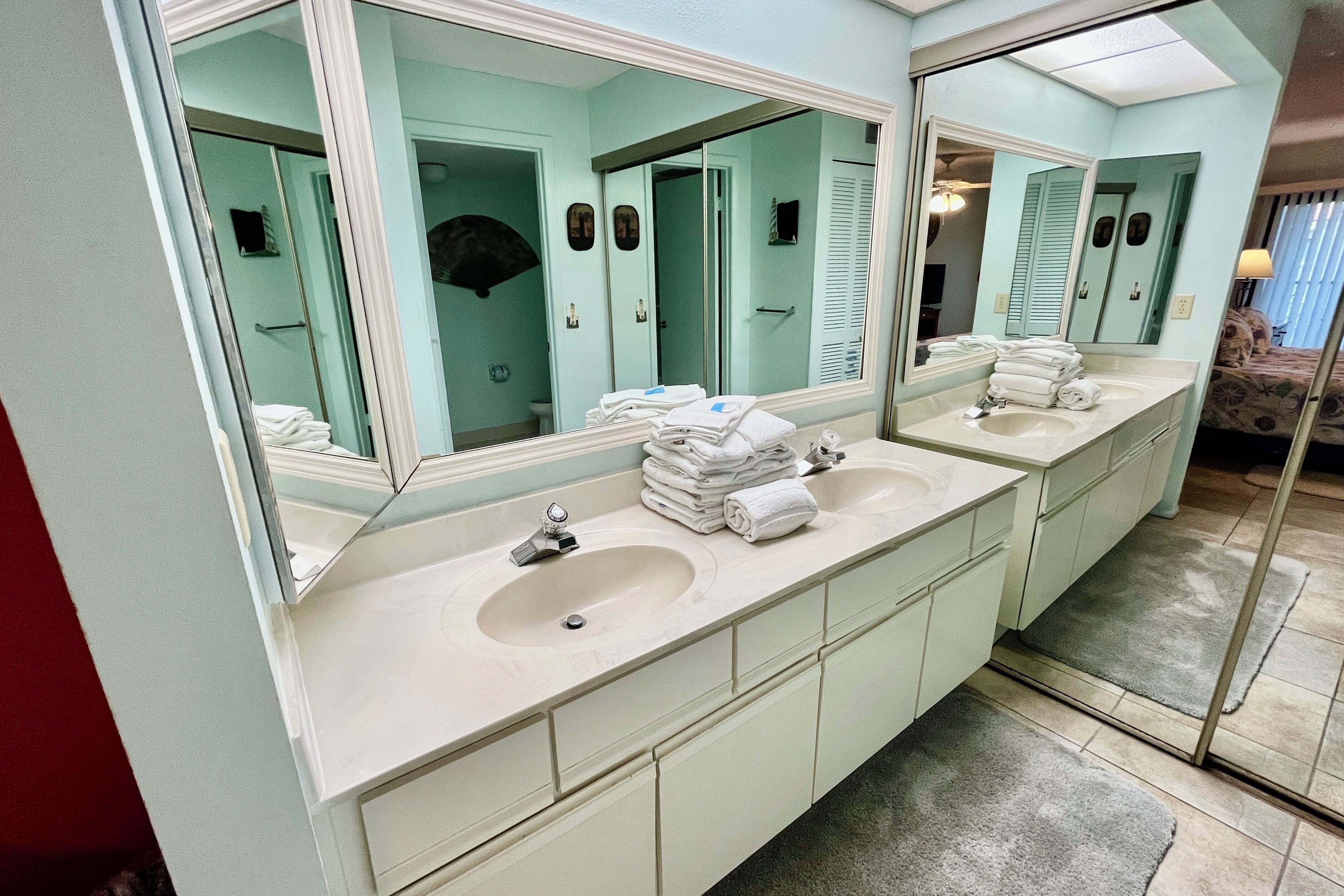 A bathroom with two sinks, a large mirror, and a towel rack.