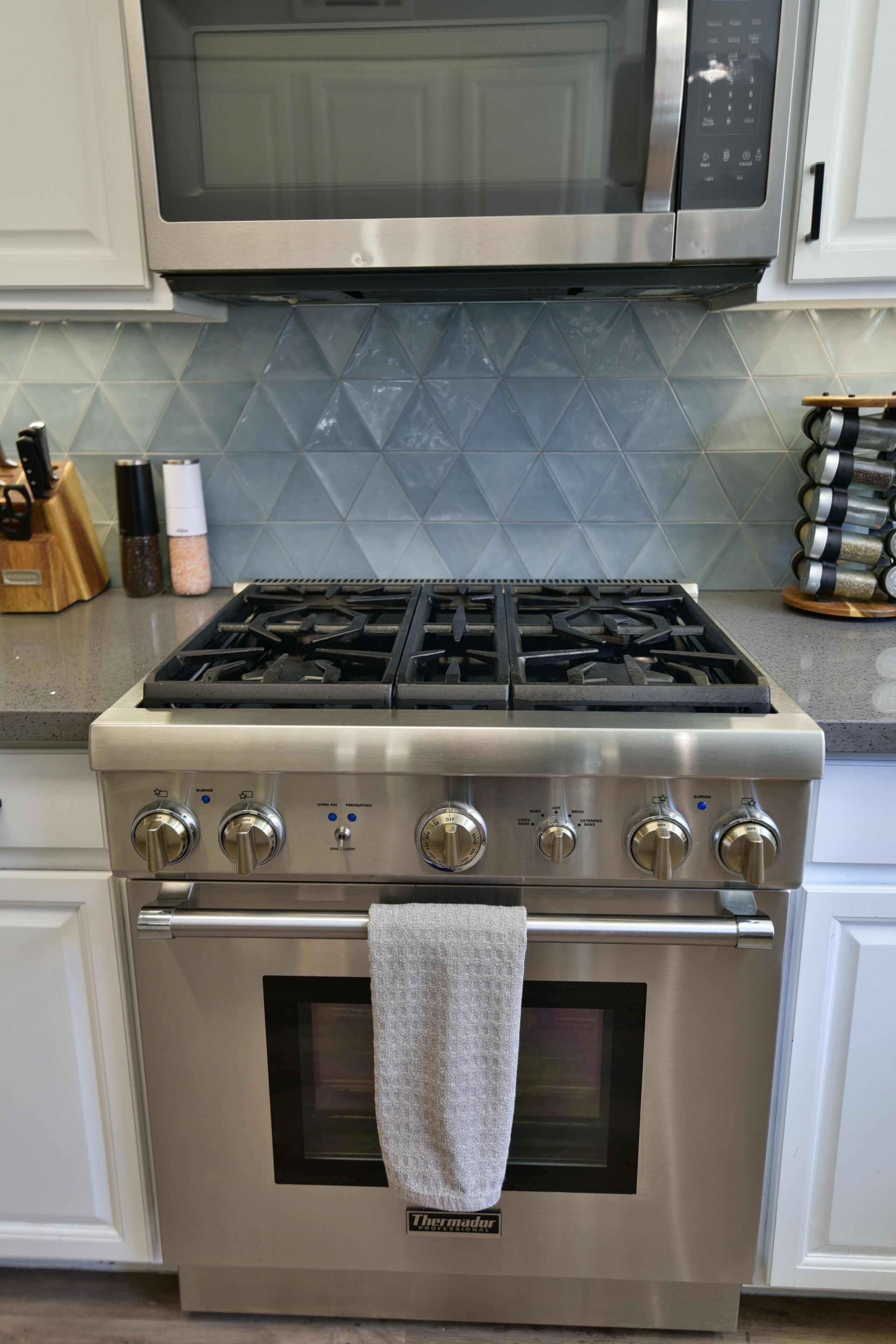 A kitchen with a stainless steel stove, oven, and microwave.