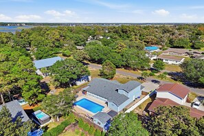 A residential area with houses, a swimming pool, and a view of a body of water. - Barbee Beach House: A Peaceful Vacation Home for a Large, Active Group (Oak Island)