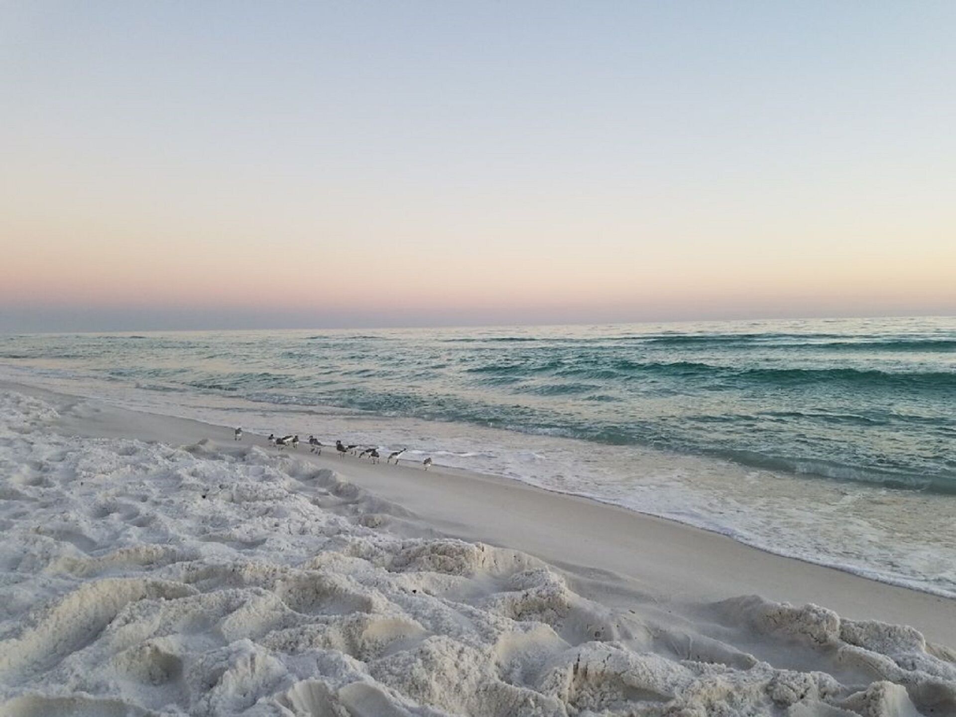 A beach with waves and a clear sky.