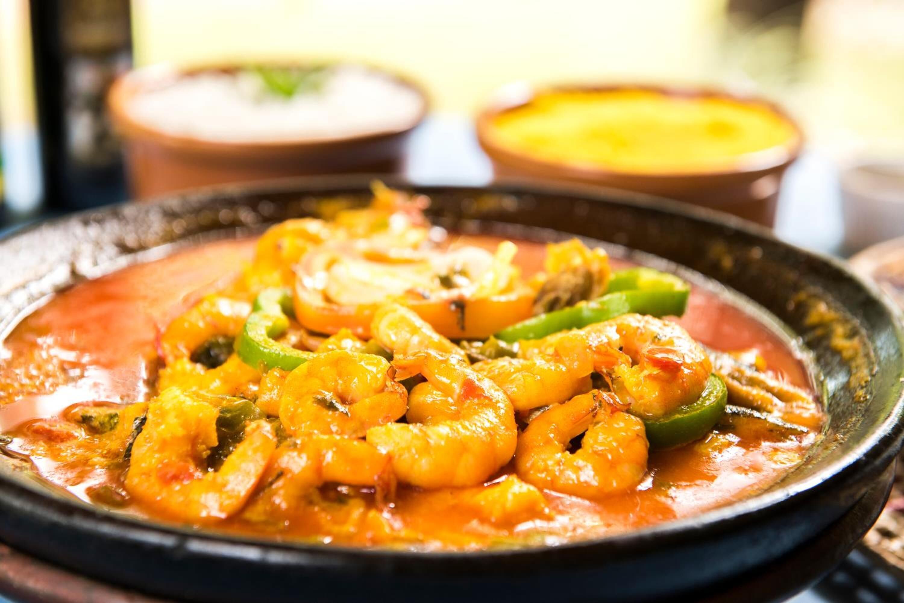 Un plat de crevettes nappées d’une sauce aux légumes.