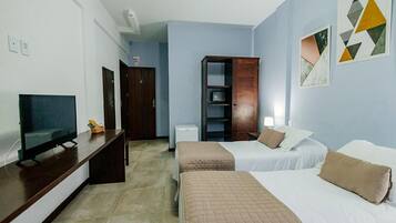 A hotel room with two beds, a TV, a desk, and a wardrobe.