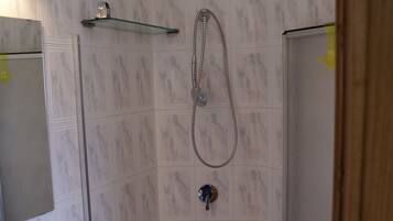 A bathroom with a shower, a sink, and a mirror.