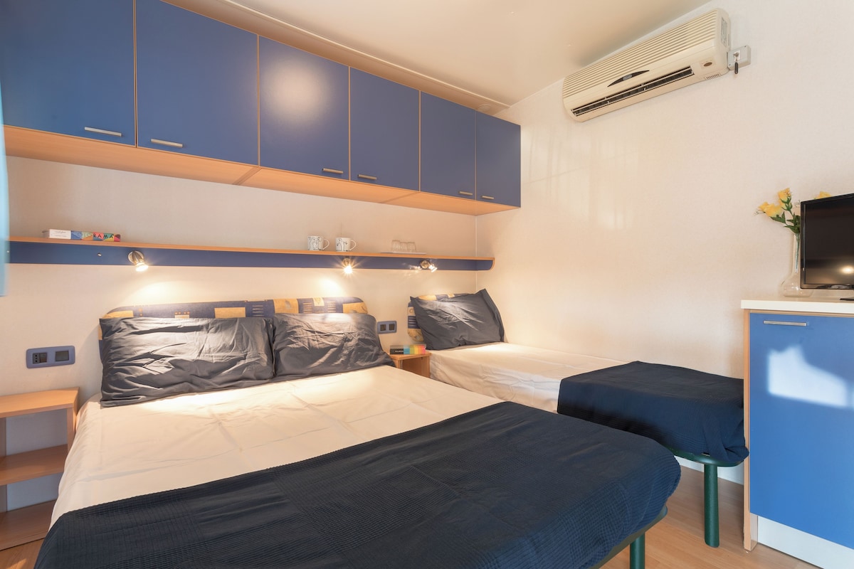 Une chambre d’hôtel avec deux lits, un bureau et une télévision.