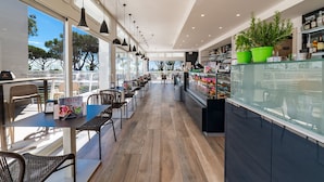 A modern cafe with a long counter, seating area, and large windows. - Camping Village Cavallino (Cavallino-Treporti)