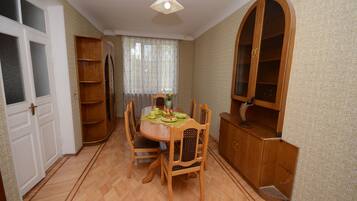 A dining area with a wooden table and chairs, a cabinet, and a door.