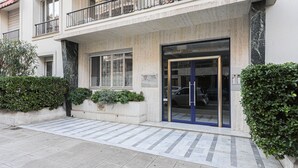 Ein modernes Gebäude mit Glastür, einem Balkon und einem Schild über der Tür.