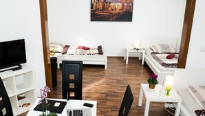 Una habitación moderna y bien iluminada con una cama, un escritorio y un televisor.