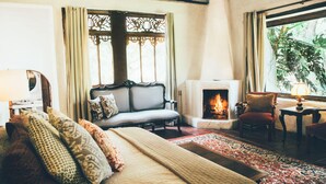 Un ambiente accogliente con camino, divano e letto.