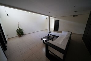 A modern bedroom with a bed, a small table, and a potted plant. - Hotel Sevilla Palenque (Palenque)