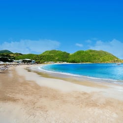 Na praia, areia branca, espreguiçadeiras, guarda-sóis