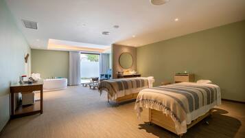 Relax in a spacious room with a large bed, bedside table, and desk, offering a view of the outdoors.