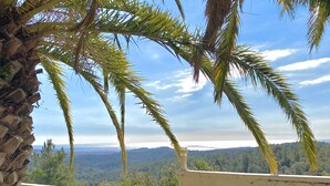 A view from a balcony with palm trees and a distant landscape. - VILLA LOS ARCOS COSTA BRAVA
Breathtaking sea views & relaxation amidst nature (Lloret de Mar)