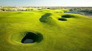 Un campo de golf con varios hoyos y cielo despejado.