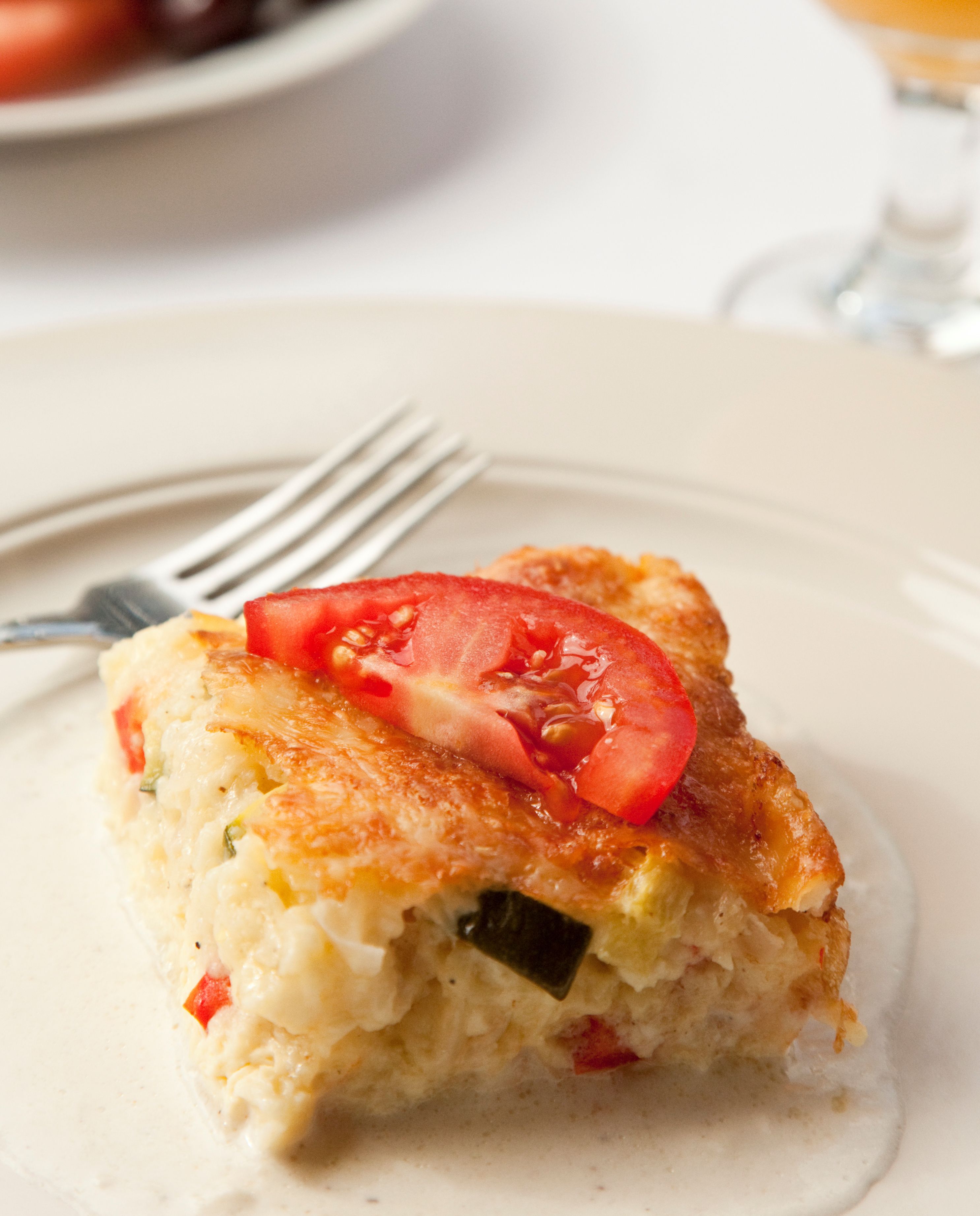Une part de quiche sur une assiette, avec une fourchette à côté.