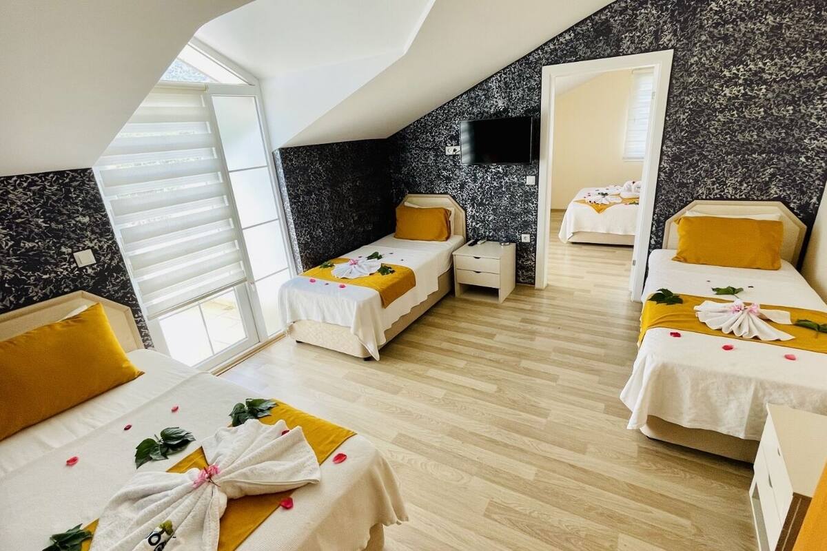 A hotel room with two beds, a TV, and a balcony.