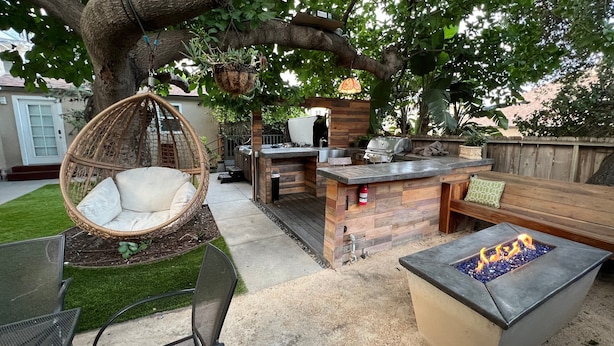 A backyard with a hanging chair, a barbecue area, a fire pit, and a wooden deck. - Cool New Remodel Near Coronado, NEW Jacuzzi, Fire Pit, BBQ, Walk to Downtown! (San Diego)