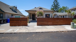 A residential house with a garage, a wooden fence, and a driveway. - Cool New Remodel Near Coronado, NEW Jacuzzi, Fire Pit, BBQ, Walk to Downtown! (San Diego)