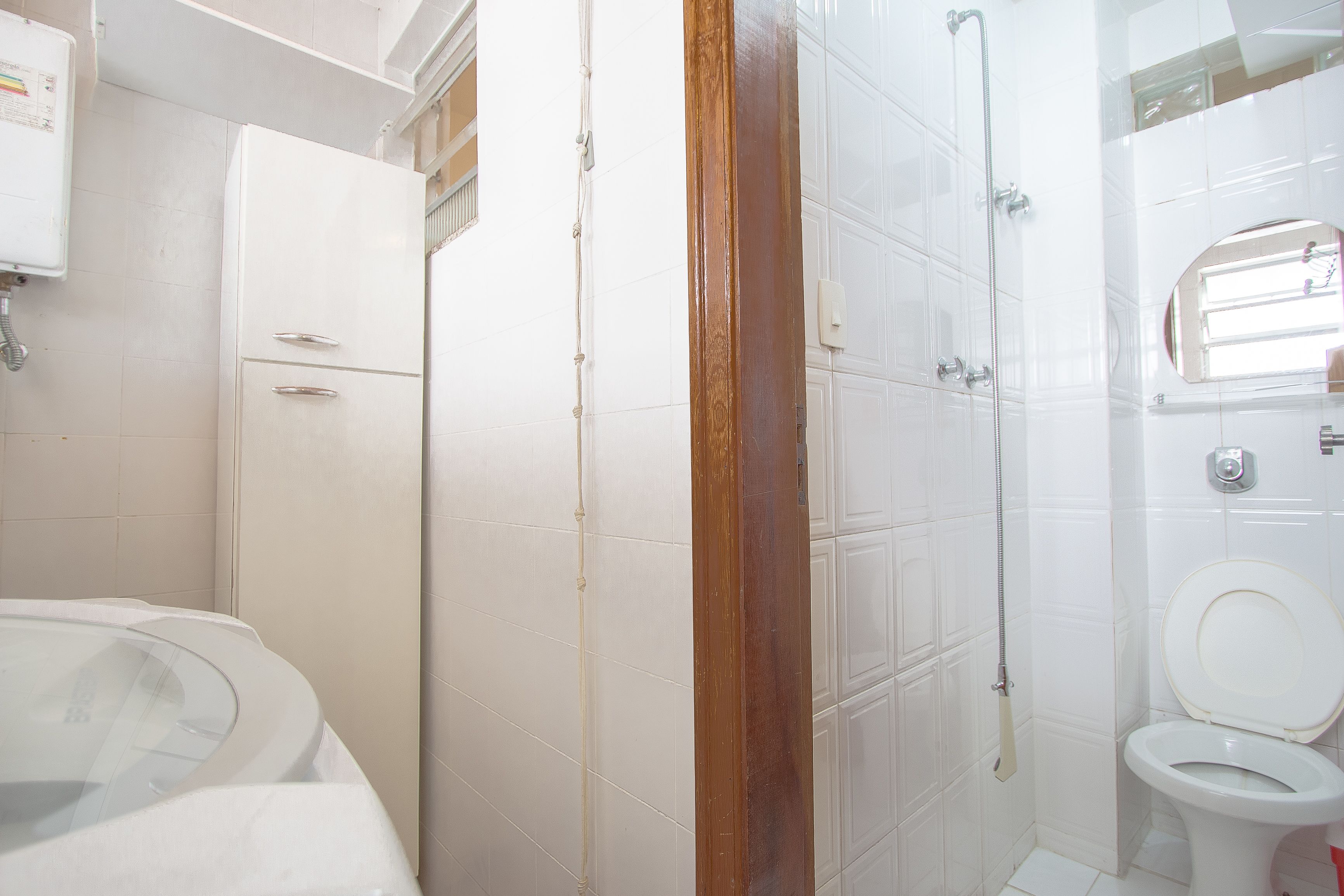 Et badeværelse med toilet, bruser og badekar.