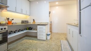A compact kitchen with white cabinets, a built-in oven, a microwave, and a sink. - LineRio Vista Mar Copacabana 228 (Rio de Janeiro)