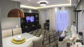 Apartamento empresarial, várias camas, vista para a lagoa | Sala de estar | TV de tela plana