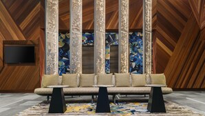 A modern lobby with a sofa set, a TV, and decorative panels. - Courtyard by Marriott New York Downtown Manhattan/Financial District (New York)